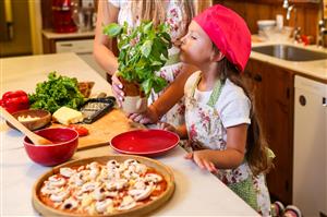 Girl smelling basil for pizza