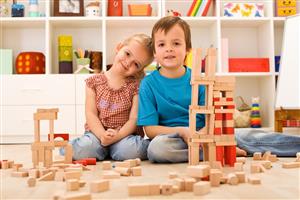 Pre-school aged girl and boy playing with building blocks
