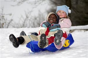 A young boy and girl sledding together