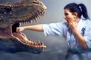 Woman in karate gi punching a dinosaur